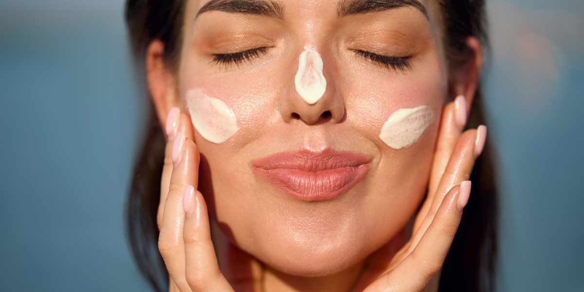 Woman applying mineral sunscreen to her face